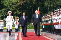 Prime Minister Pham Minh Chinh (L) and Russian Prime Minister Mikhail Vladimirovich Mishustin review the guard of honour of the Vietnam People's Army at the official welcome ceremony. (Photo: VNA)