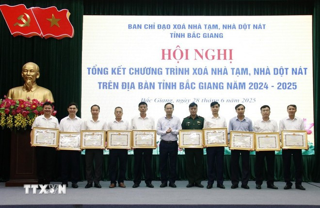 Vice Chairman of the Bac Giang provincial People's Committee Pham Van Thinh hands over certificates of merit to individuals with outstanding contributions to the housing support programme. (Photo: VNA) bac-giang.jpg