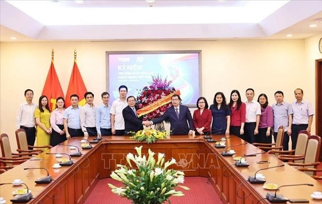 Vice Chairman of the Party Central Committee’s Commission for Information, Education and Mass Mobilisation Lai Xuan Mon presents flowers to congratulate VNA journalists. (Photo: VNA) chuc-mung.jpg