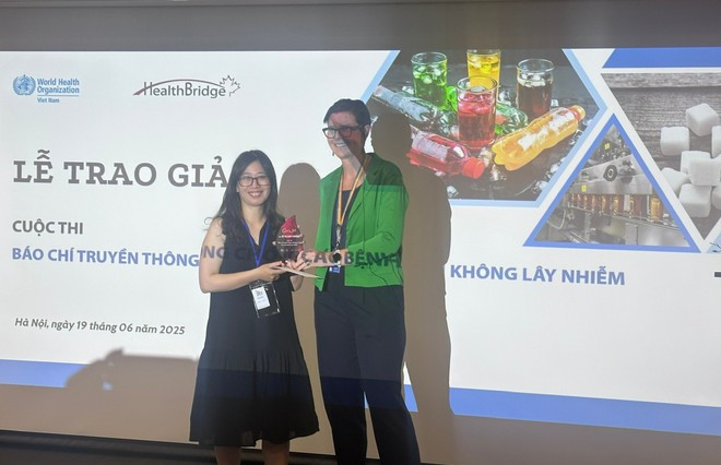 Dr Angela Pratt, WHO Representative in Vietnam, presents the first prize to journalist Vu Thi Nam Phuong from the Dan tri e-newspaper. (Photo: VietnamPlus) 2.jpg