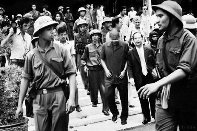 Liberation army soldiers escort President Duong Van Minh and Prime Minister Vu Van Mau of the Saigon puppet regime to the radio station to deliver their unconditional surrender statement. (Photo: VNA) liberation-army.jpg
