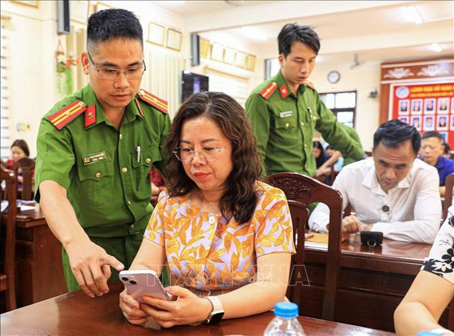 Public security officers of Dien Bien province provide local people with guidance on commenting on the draft amendments and supplements to the 2013 Constitution via VNeID on personal smartphones. (Photo: VNA) hien-phap-1625-10.jpg