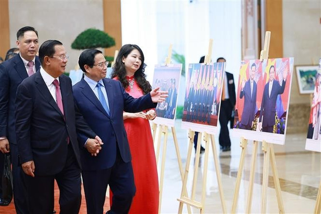 Prime Minister Pham Minh Chinh and President of the Cambodian People's Party (CPP) and President of the Cambodian Senate Hun Sen visit a photo exhibition on bilateral cooperation held by the Vietnam News Agency. (Photo: VNA) pham-minh-chinh-hun-sen-vna.jpg