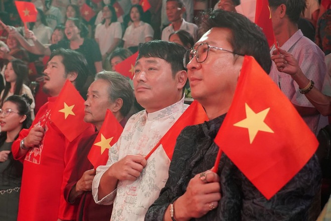 The production crew from the RoK wearing Ao dai, holding the Vietnamese national flag watching the show. From right to left: artistic director Park Hyun Woo, director Cho Joon Hui (Vietnam National Drama Theatre) e-kip-san-xuat-tu-han-quoc-mac-ao-dai-cam-quoc-ky-viet-nam-xem-chuong-trinh-tu-phai-qua-thu-nhat-la-giam-doc-nghe-thuat-park-hyun-woo-thu-hai-la-dao-dien-cho-joon-hui-anh-nha-hat-kich-viet-nam.jpg