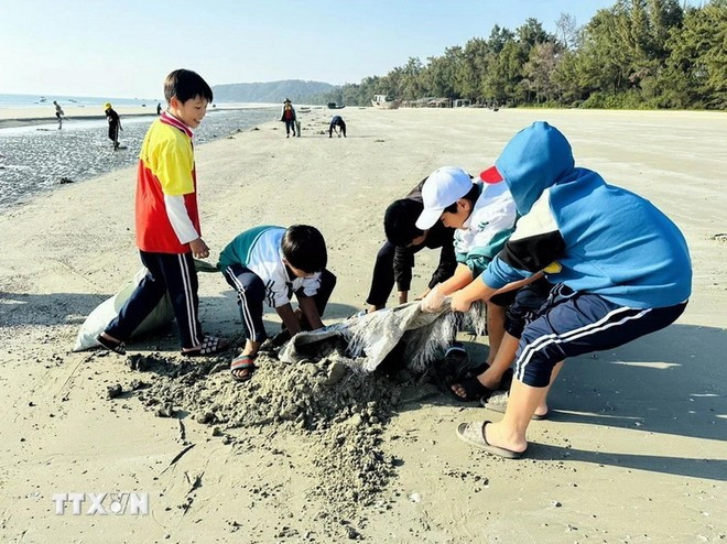 Students on Co To Island collect trash and clean the beach. (Photo: VNA)