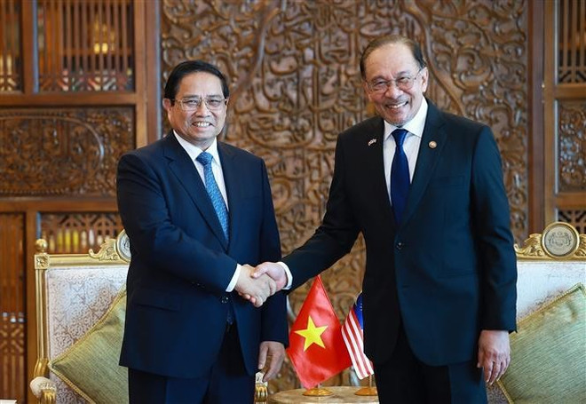 Vietnamese Prime Minister Pham Minh Chinh (L) shakes hands with his Malaysian counterpart Anwar Ibrahim at their meeting in Kuala Lumpur on May 25. (Photo: VNA)