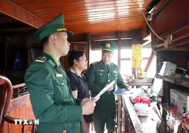 Staff from Quynh Phuong Border Guard Station in Nghe An province check the vessel monitoring equipment on fishermen's fishing boats before it leaves a local port. (Photo: VNA) iuu-nghe-an-1.jpg