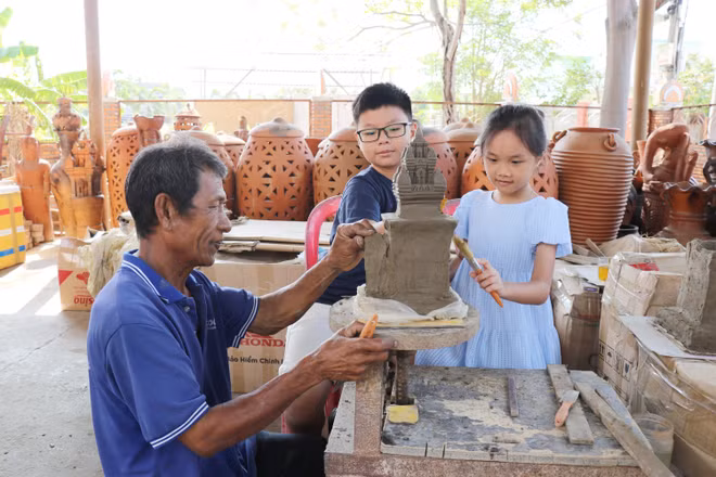 Children experience making small ceramic towers at Bau Truc Cham Pottery Cooperative in Phuoc Dan town of Ninh Phuoc district, Ninh Thuan province. (Photo: VNA)