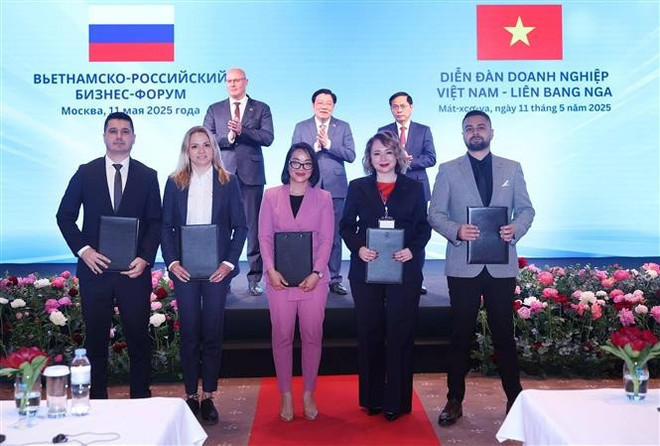 Vietnamese and Russian businesses exchange cooperation documents at the forum. (Photo: VNA) vna-potal-tong-bi-thu-to-lam-du-dien-dan-doanh-nghiep-viet-nam-nga-8025547.jpg