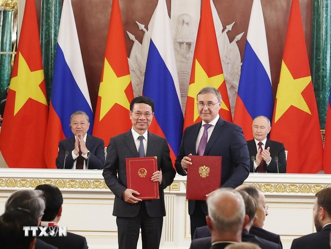 Party General Secretary To Lam and President Vladimir Putin witness the signing of an agreement between the two ministries of ccience and technology. (Photo: VNA) to-lam-putin-cooperation-agreement-vna.jpg