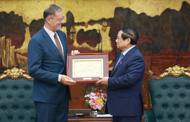 Prime Minister Pham Minh Chinh gives a present to French Ambassador to Vietnam Olivier Brochet. (Photo: VNA) vna-potal-thu-tuong-pham-minh-chinh-tiep-dai-su-phap-tai-viet-nam-8029989.jpg