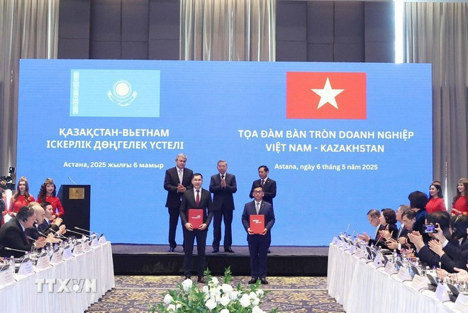 Party General Secretary Lam, Deputy PM of Kazakhstan Kosherbayev, and Vietnamese Deputy Prime Minister and Foreign Minister Bui Thanh Son witness the exchange of a business franchise agreement between Vietjet Air and Qazaq Air. (Photo: VNA) toa-dam.jpg