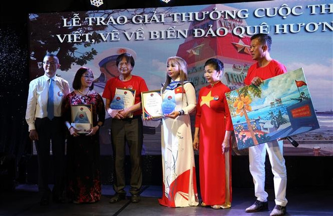 Vietnamese Ambassador to Germany Vu Quang Minh (first, left) and three first-prize winners of the “For the Homeland’s Seas and Islands” writing and painting contest. (Photo: VNA) vna-potal-trao-giai-cuoc-thi-viet-va-ve-vi-bien-dao-que-huong-danh-cho-nguoi-viet-o-nuoc-ngoai-8121708.jpg