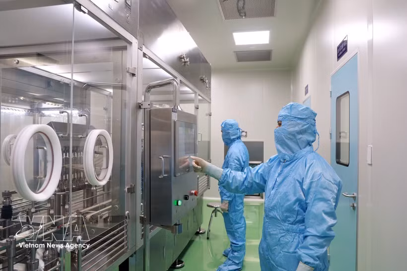 Researchers of the Institute of Vaccines and Medical Biologicals operate equipment in the vaccine production process. (Illustrative photo: VNA)