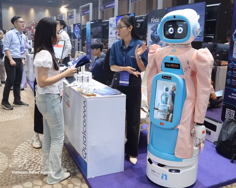 Visitors learn about a robot model designed to care for the elderly at Qualcomm’s booth. (Photo: VNA)