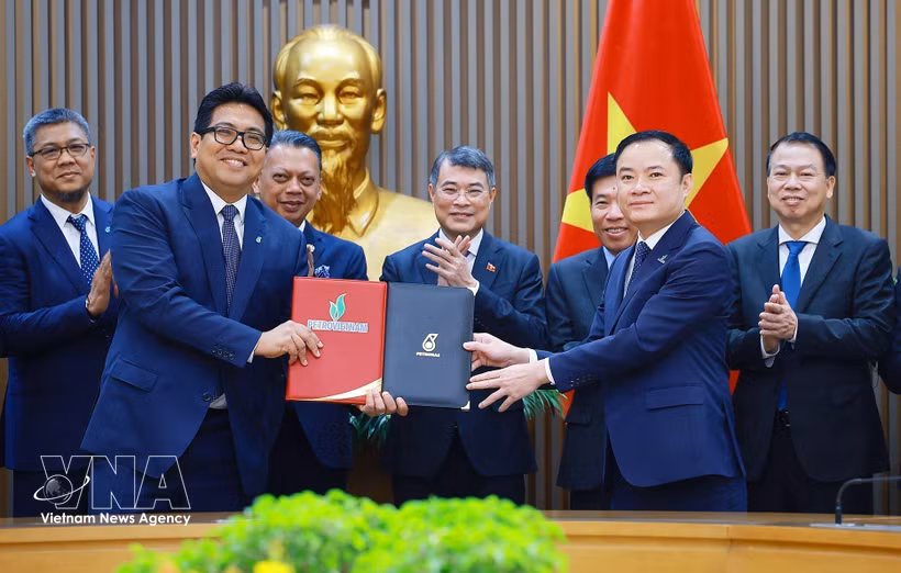 Prime Minister Le Minh Hung (C) witnesses the exchange of the Strategic Alliance Agreement between Petrovietnam and PETRONAS. (Photo: VNA)
