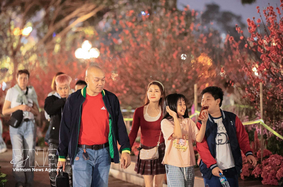 A family takes their children to enjoy the pedestrian area around Hoan Kiem Lake in Hanoi at the moment of welcoming the New Year. (Photo: Hoang Hieu – VNA)