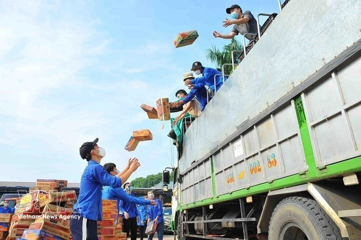 Hanoi youth receive and deliver essential supplies to lockdown and quarantine areas, as well as to disadvantaged people affected by the COVID-19 pandemic (September 2021). (Photo: Minh Duc/VNA)