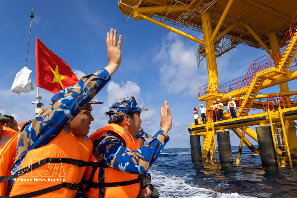 Farewell waves are exchanged in the middle of the sea. (Photo: Xuan Quy – VNA)
