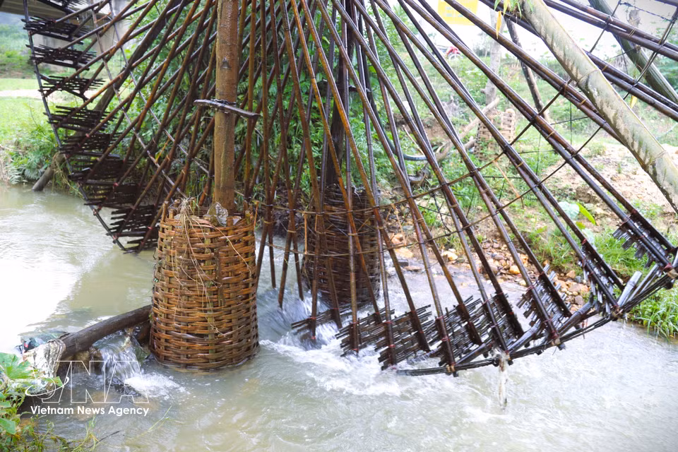 The weight of the water wheel is supported by a system of pillars embedded deep into the streambed and reinforced with stones packed in bamboo baskets, ensuring the structure remains upright and stable. (Photo: Xuan Tien – VNA)