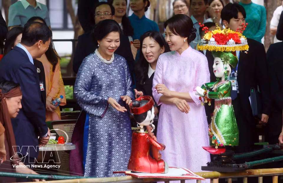 Madame Ngo Phuong Ly, spouse of Party General Secretary and State President To Lam, and Madame Kim Hae Kyung, spouse of Republic of Korea President Lee Jae Myung, interact with artists and try operating puppets. (Photo: Pham Kien - VNA)