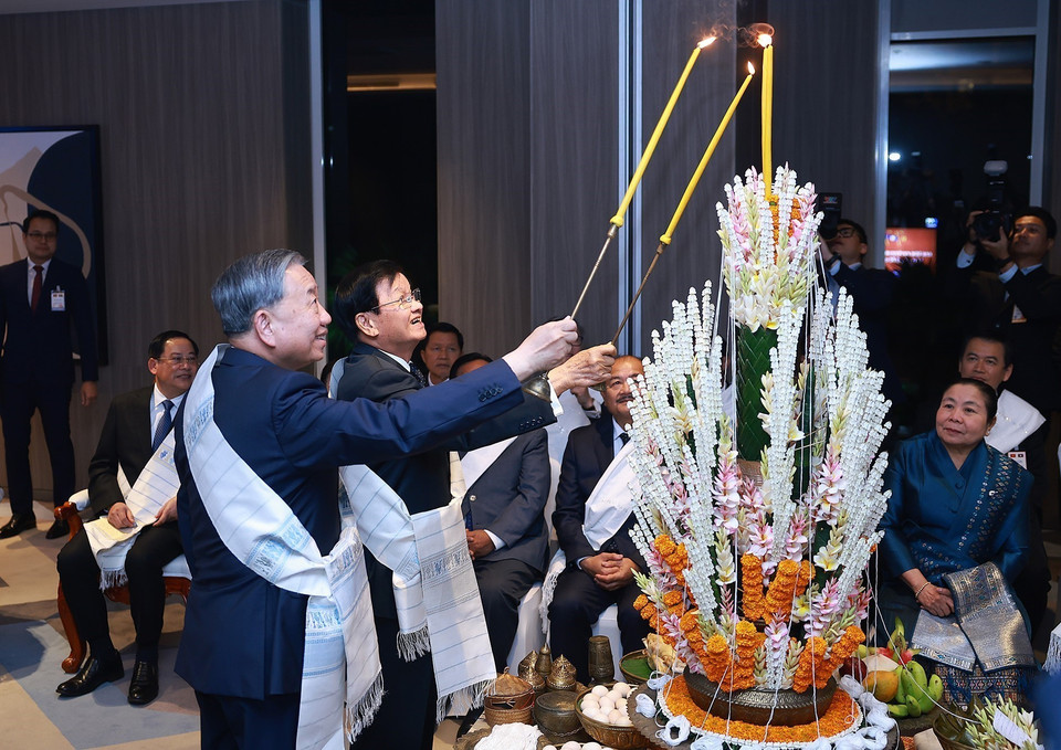 Party General Secretary To Lam and Party General Secretary and President of Laos Thongloun Sisoulith perform the traditional Lao wrist-tying ritual at the ceremony. (Photo: Duong Giang – VNA)