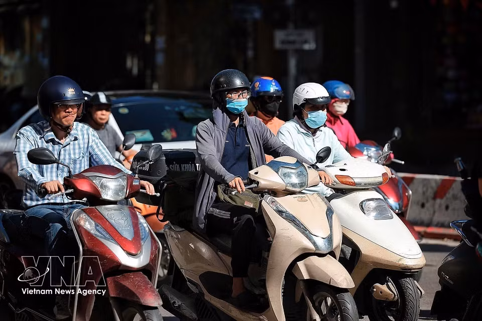 Commuters on Hanoi’s central streets wrap themselves in sun-protective clothing, sunglasses and face masks to cope with soaring temperatures from early morning. (Photo: Pham Tuan Anh/VNA)