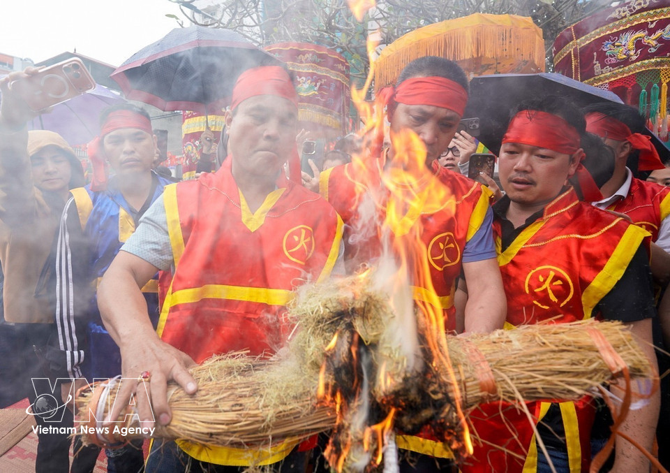Young men from each team make fire with straw. (Photo: Khanh Hoa – VNA)