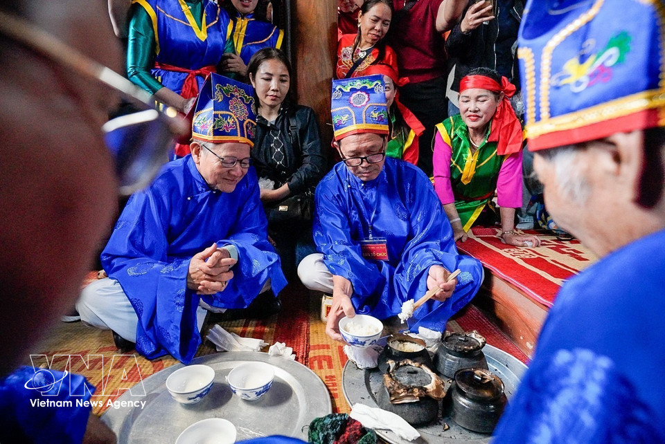 Four pots of rice are carried into the communal house to be offered to the village tutelary deity, after which village elders taste and judge the rice to select the team with the best-cooked dish. (Photo: Khanh Hoa – VNA)