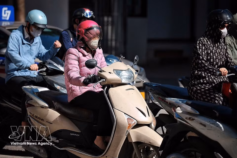 Commuters on Hanoi’s central streets wrap themselves in sun-protective clothing, sunglasses and face masks to cope with soaring temperatures from early morning. (Photo: Pham Tuan Anh/VNA)