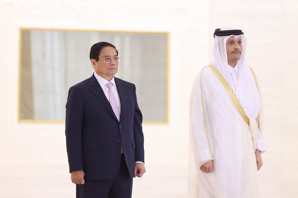 Prime Minister Pham Minh Chinh and Qatari Prime Minister Sheikh Mohammed bin Abdulrahman bin Jasim Al-Thani listen to the national anthems of both nations played by a military band. (Photo: Duong Giang-VNA)