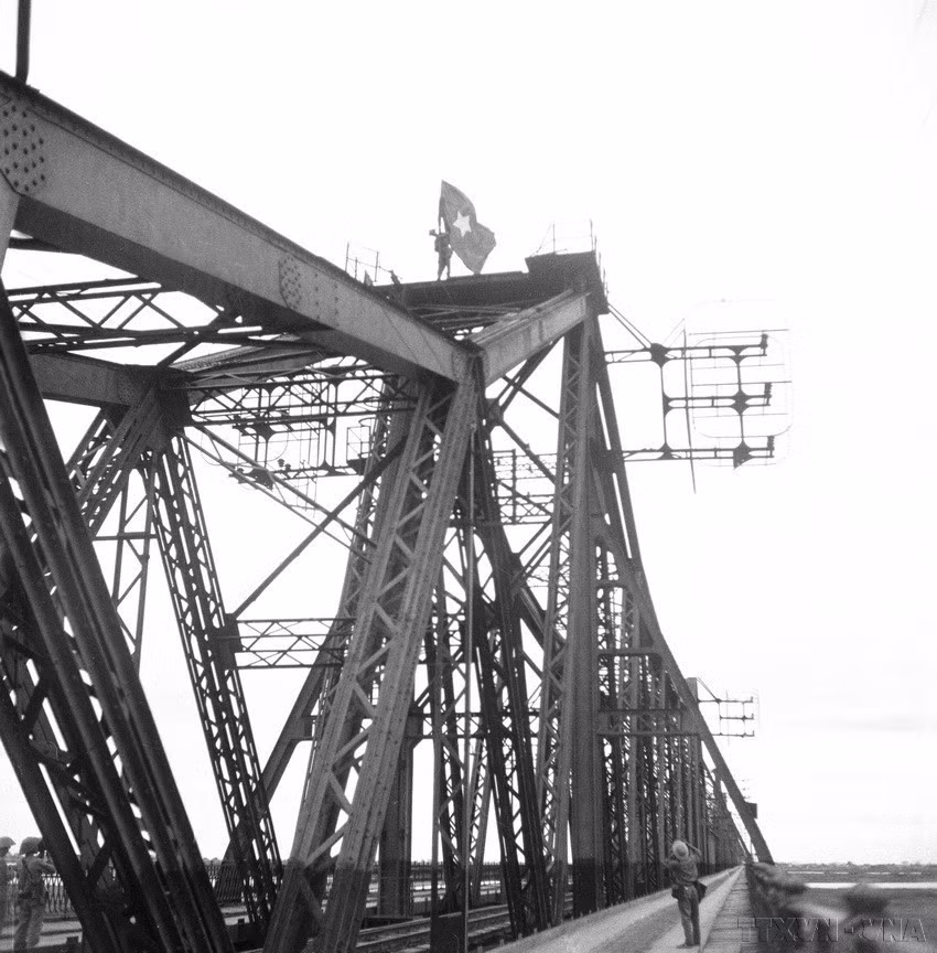 The soldiers raise the liberation flag on the top of Long Bien Bridge. (Photo: File – VNA)