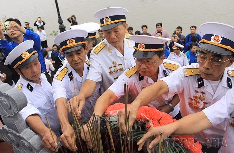 Veterans of the no-number ships light incense in tribute to their fallen comrades at the monument for No-number ships at K15 wharf, Do Son ward, Hai Phong city. (Photo: The Duyet - VNA)