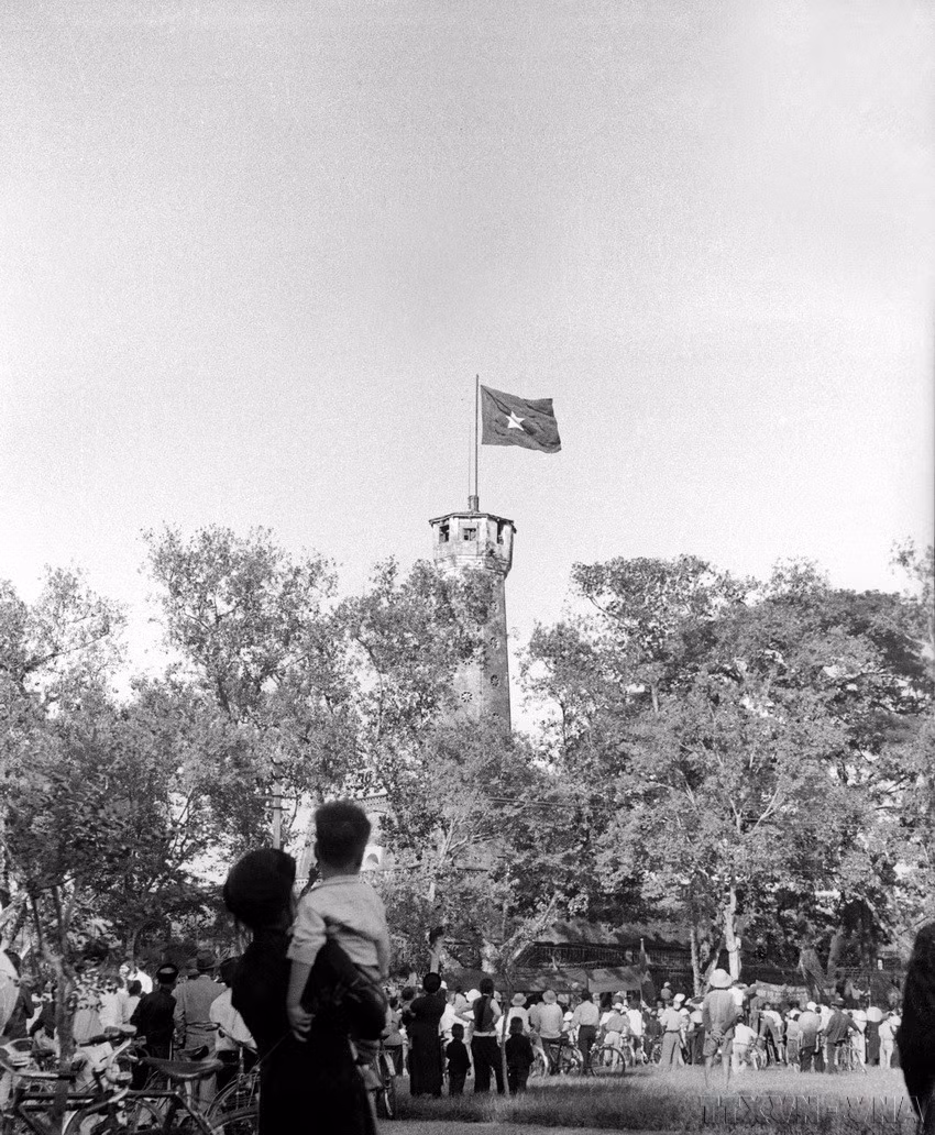 The people joyfully look towards the national flag flying on the Hanoi Flag Tower on the liberation day, October 10, 1954. (Photo: File – VNA)