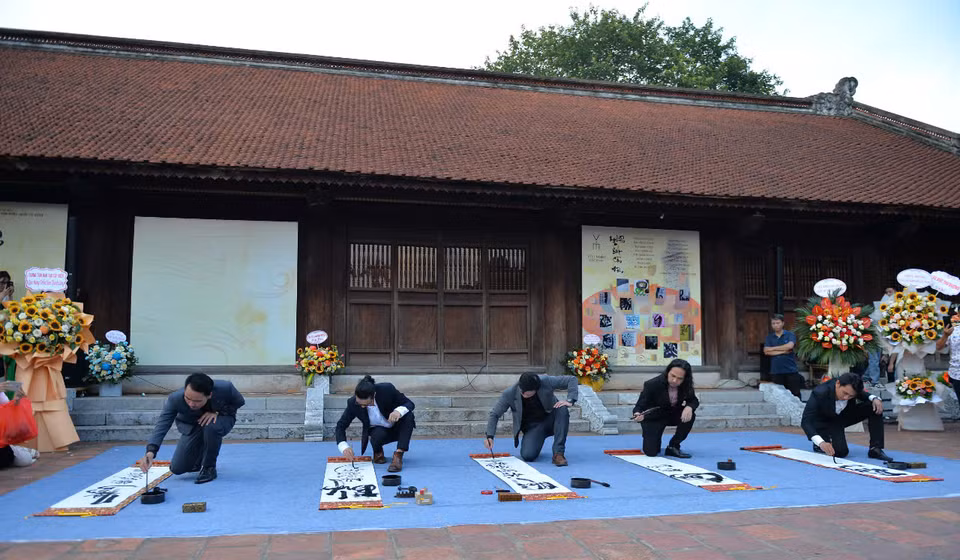 People perform Vietnamese calligraphy at the Temple of Literature. (Photo: VNA)