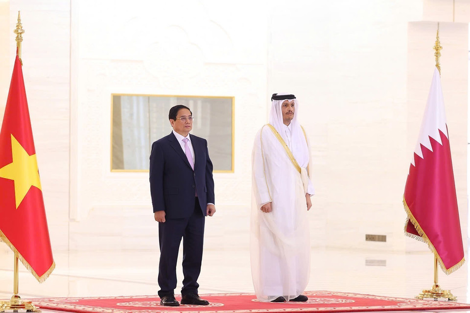 Prime Minister Pham Minh Chinh and Qatari Prime Minister Sheikh Mohammed bin Abdulrahman bin Jasim Al-Thani listen as the military band plays the national anthems of both countries. (Photo: Duong Giang-VNA)