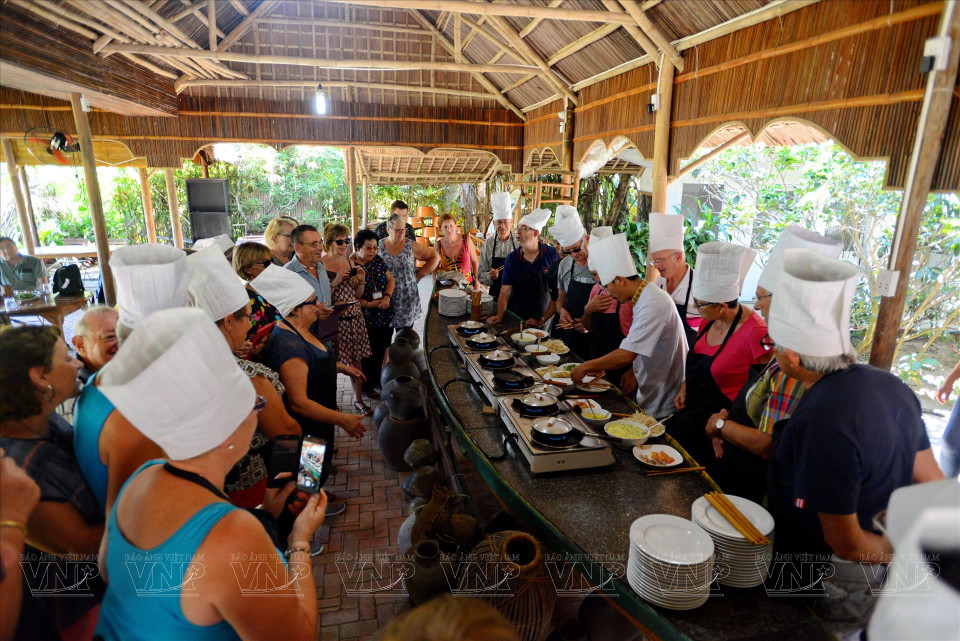Foreign tourists participate in a cooking class at a restaurant in Tra Que village. (Photo: Thanh Hoa/VNA)