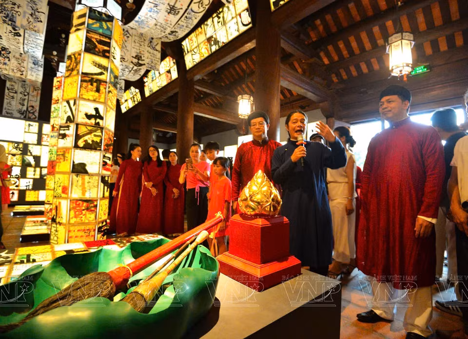 A calligrapher explains the meanings of his works to the audience. (Photo: VNA)