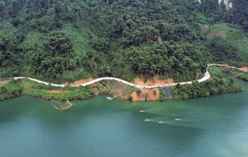 Tourists to Pa Khom Bay can travel by road along winding paths that surround the mountains, adorned with lush vegetation. (Photo: VNA)
