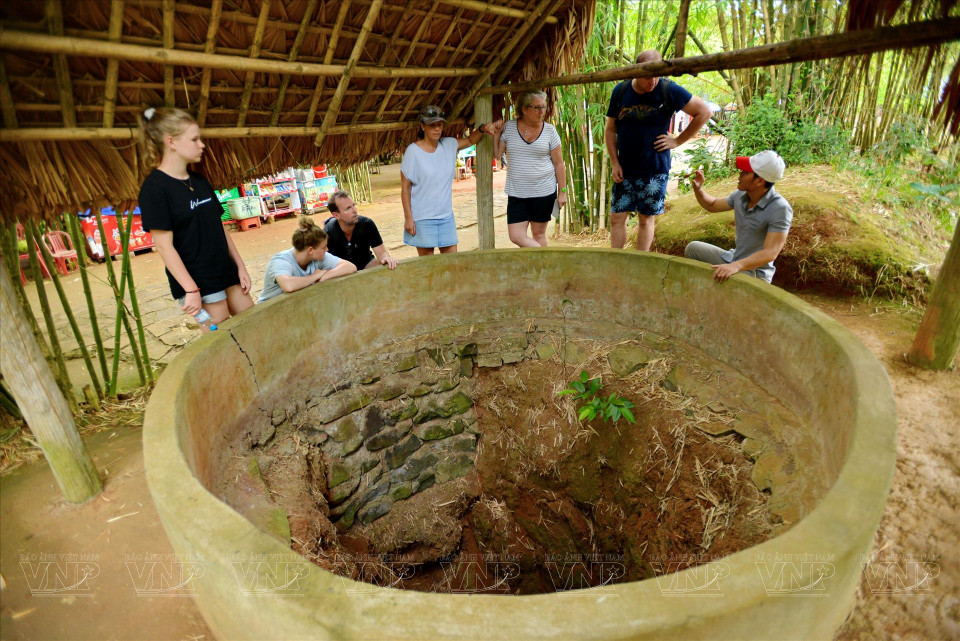 Foreign tourists stand beside a water well in the Vinh Moc tunnel. (Photo: VNA) (Photo: VNA)
