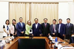 Nguyen Van Duoc (middle), Chairman of Ho Chi Minh City People's Committee, holds a working session with Sarah Kemp (4th from left), Vice President of International Government Affairs at Intel Corporation on July 8. (Photo: VNA)