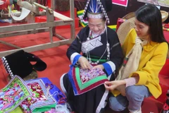 A visitor learn about the traditional embroidery craft of the Pa Di ethnic group in Muong Khuong commune (Photo: VNA)
