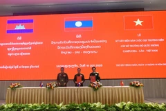 The defence ministers of Vietnam, Laos and Cambodia sign the minutes of their annual meeting in Vientiane on October 15. (Photo: VNA)