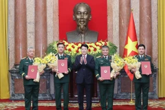 State President Luong Cuong (C) hands over the decisions to promote Members of the Party Central Committee and the Central Military Commission, and Deputy Defence Ministers Nguyen Hong Thai, Nguyen Van Hien and Nguyen Truong Thang; and Deputy Chief of the General Staff of the VPA Nguyen Quang Ngoc, from the rank of Lieutenant General to Senior Lieutenant General. (Photo: VNA)