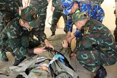 AMET members practise receiving and securing a patient on a stretcher in preparation for transport to an ambulance (Photo: VNA)