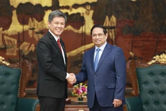 Prime Minister Pham Minh Chinh (R) and Chan Chun Sing, Assistant Secretary-General of the People’s Action Party (PAP) of Singapore, Coordinating Minister for Public Services, and Minister for Defence, in Hanoi on July 22. (Photo: VNA)