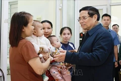 Prime Minister Pham Minh Chinh talks to people receiving medical services at the Yen Khuong health station in Thanh Hoa province on November 9. (Photo: VNA)