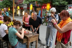 Tourists experience silver craft in Hang Bac street of Hanoi (Photo: VNA)
