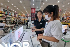 Users look for smartphones that support 5G connection at a store in Phan Rang - Thap Cham city, Ninh Thuan province. (Photo: VNA)