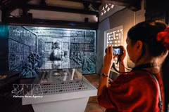 Visitors enjoy the "Stone History Preserves Memories" exhibition, featuring a traditional format combined with digital technology solutions (Photo: VNA)
